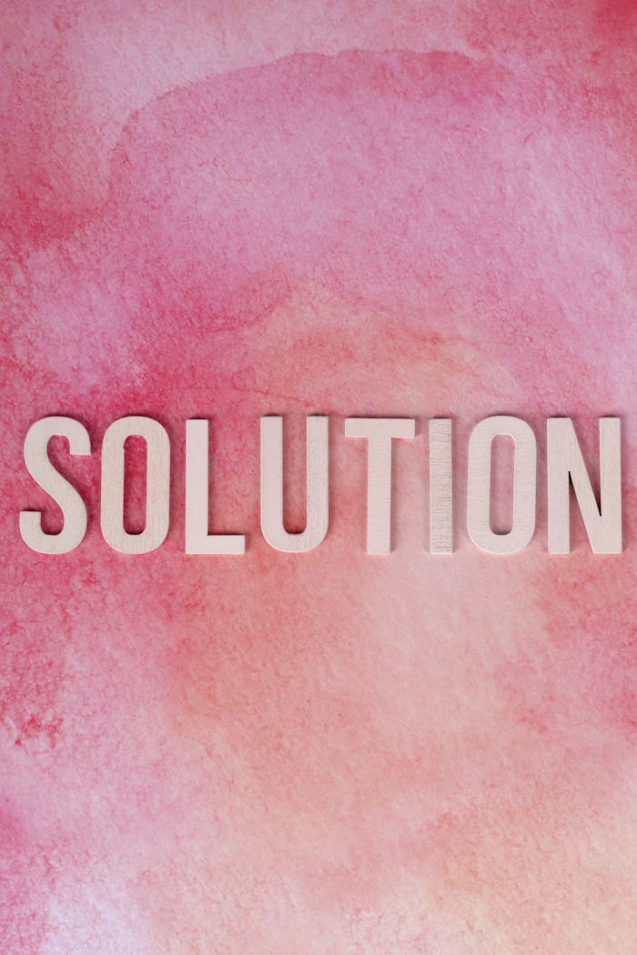 Inspirational 'Solution' text on a vibrant pink watercolor background for motivation and problem-solving concepts.