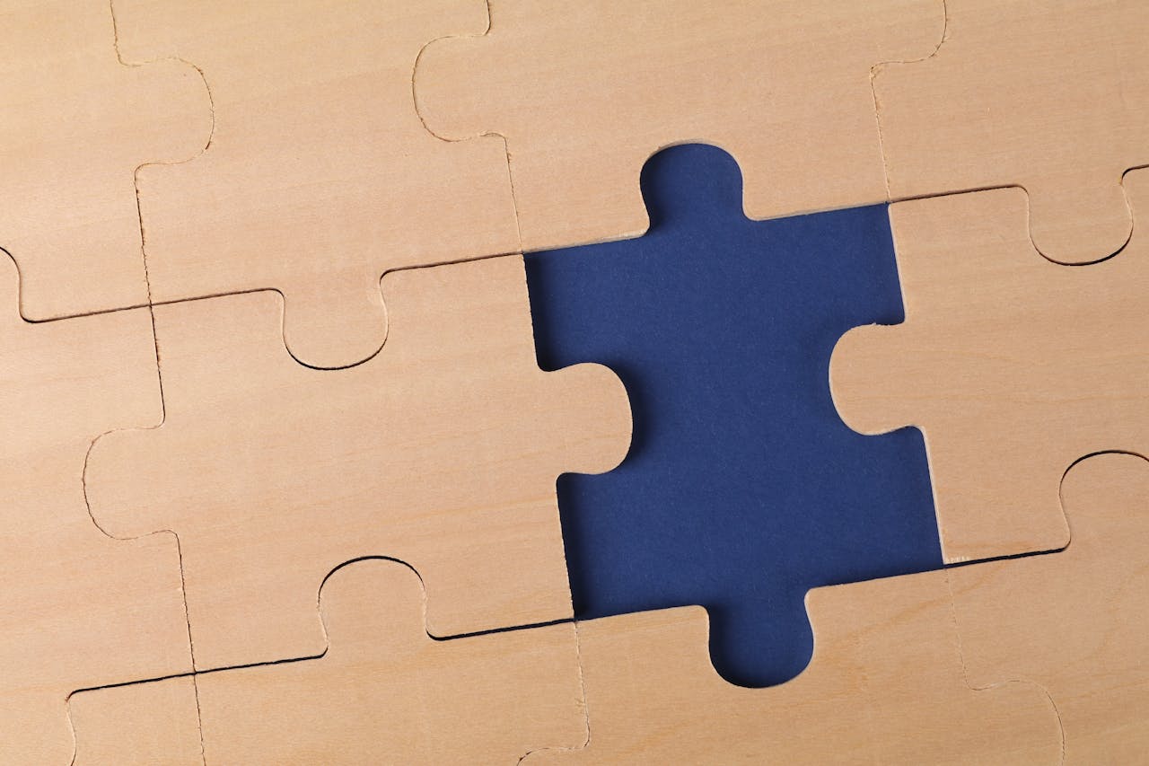 Close-up of an unfinished wooden puzzle with a missing piece, highlighting problem-solving concepts.