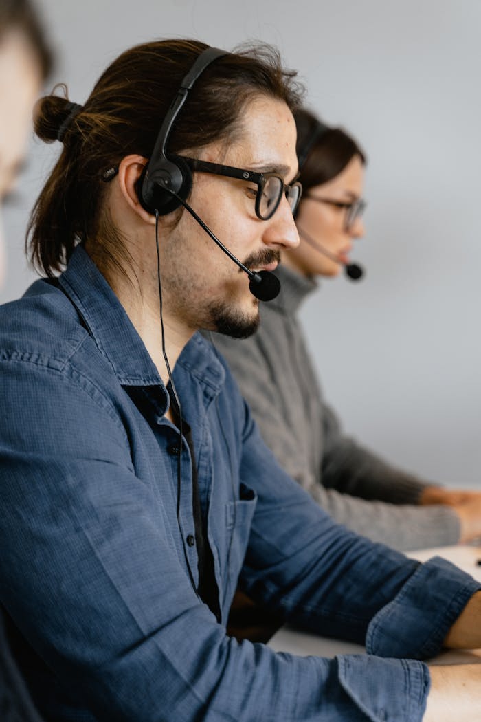 Call center agents focused on assisting customers using headsets in a modern office.